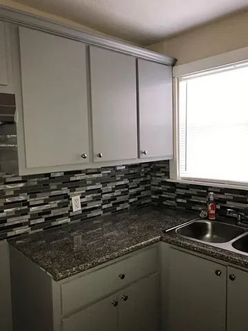 a kitchen with sink a window and cabinets
