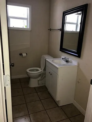 a bathroom with a toilet sink and mirror