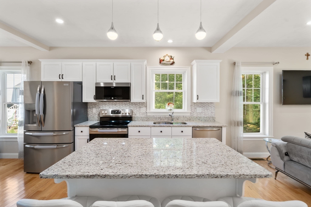 a kitchen with kitchen island a counter top space appliances and a window
