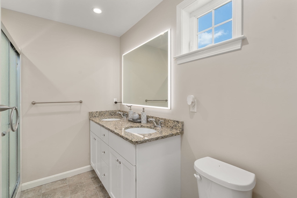 26 Brookview Lane, Unit 26 Mendon, MA 01756 - Photo 13 of 23 a bathroom with a granite countertop sink toilet and mirror