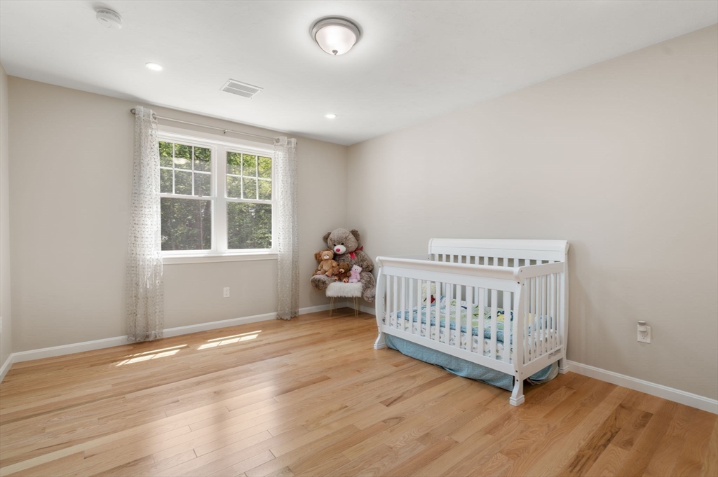 26 Brookview Lane, Unit 26 Mendon, MA 01756 - Photo 15 of 23 a bedroom with a bed and wooden floor