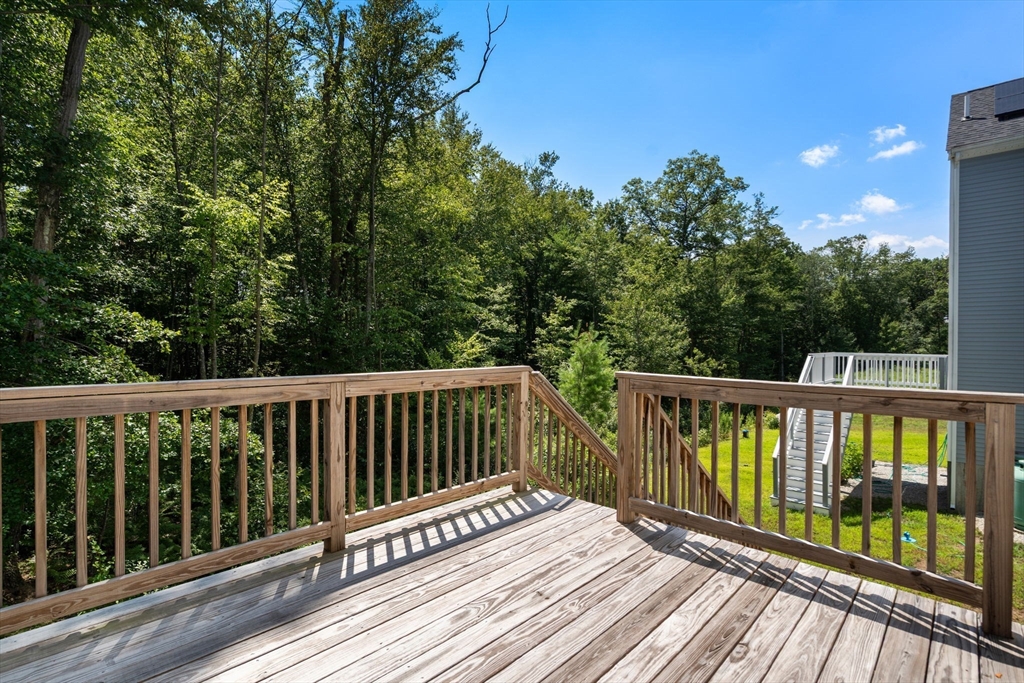 26 Brookview Lane, Unit 26 Mendon, MA 01756 - Photo 19 of 23 a balcony with wooden floor and fence