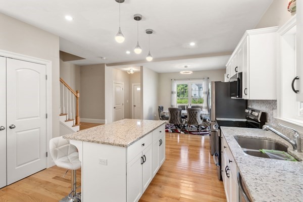 26 Brookview Lane, Unit 26 Mendon, MA 01756 - Photo 4 of 23 a large white kitchen with a large window a sink and stainless steel appliances