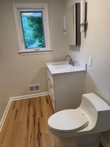 a bathroom with a toilet sink and mirror