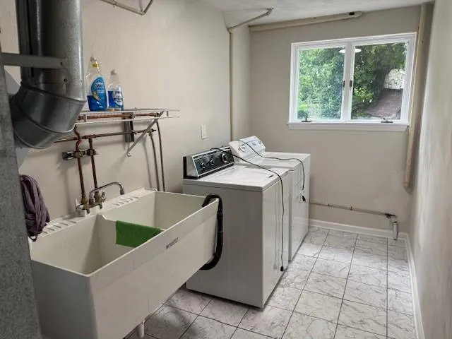 a room with a sink a washer and dryer