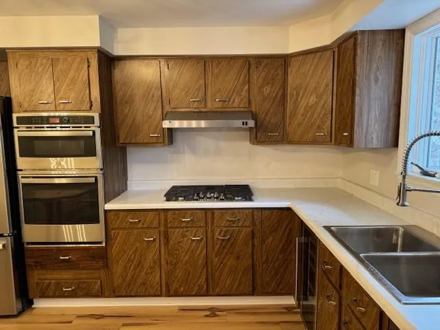 a kitchen with a sink and a stove top oven