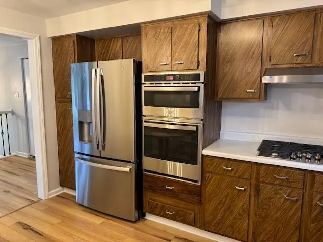 a kitchen with granite countertop stainless steel appliances and wooden cabinets