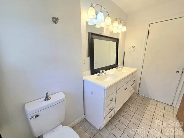 a bathroom with a double vanity sink mirror and toilet
