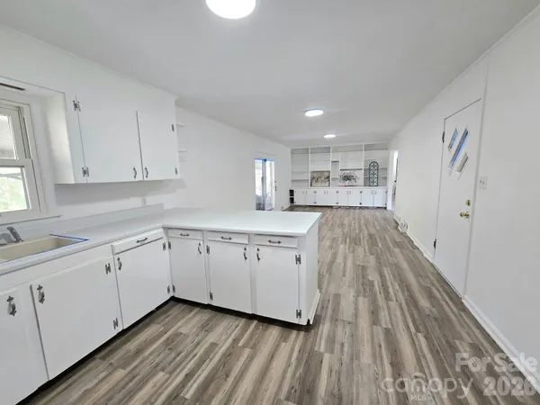 a kitchen with sink cabinets and wooden floor