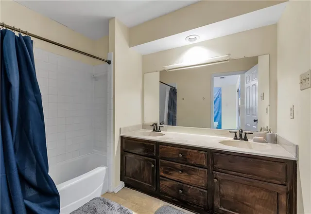 a bathroom with a tub sink and mirror