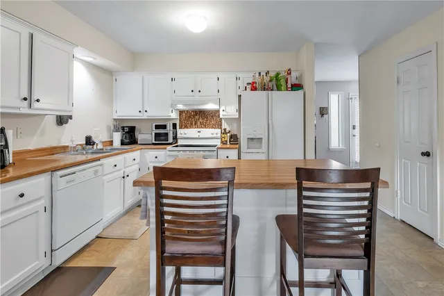 a kitchen with stainless steel appliances kitchen island granite countertop a refrigerator and cabinets