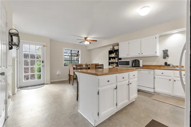 a kitchen with granite countertop white cabinets and white appliances