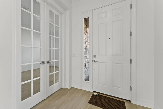 a kitchen with stainless steel appliances granite countertop a refrigerator a sink a stove and a wooden floors