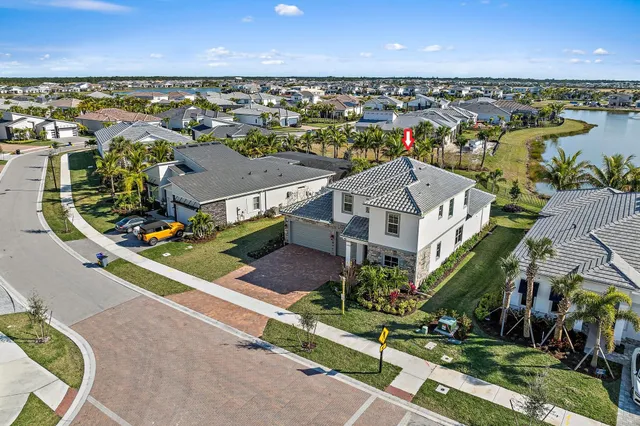 an aerial view of residential houses with outdoor space and ocean view