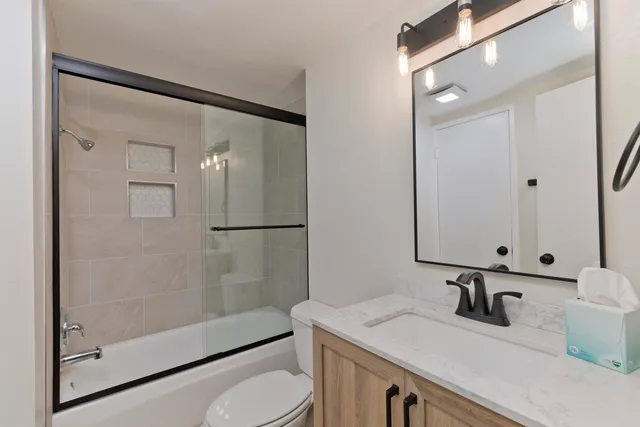 a bathroom with a sink a toilet and shower