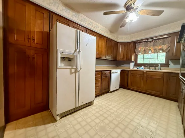a view of an empty room with a kitchen and wooden floor