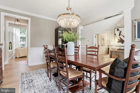 a view of a dining room and livingroom with furniture wooden floor a chandelier
