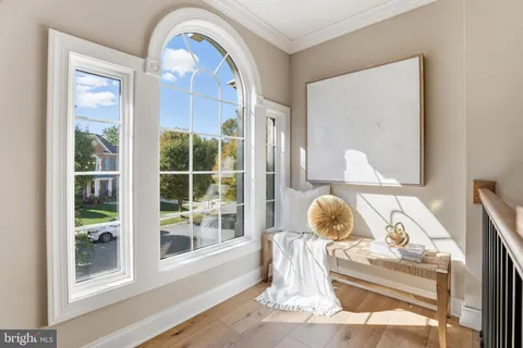 a view of a hallway with wooden floor and stairs