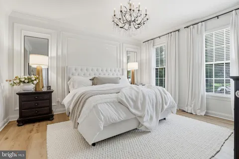 a spacious bedroom with a bed and a chandelier