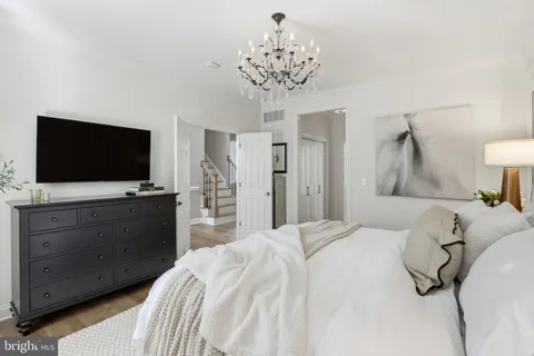 a bedroom with a bed and a flat tv screen on dresser