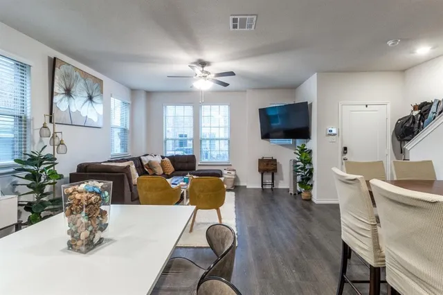 a living room with furniture a flat screen tv and kitchen view
