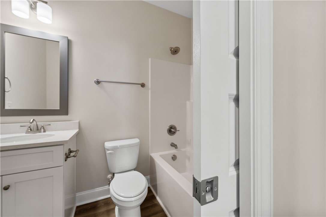 112 Oak Grove Road Norris, SC 29667 - Photo 19 of 19 This bright bathroom features a modern vanity, a sleek mirror, and a convenient bathtub with an overhead shower.