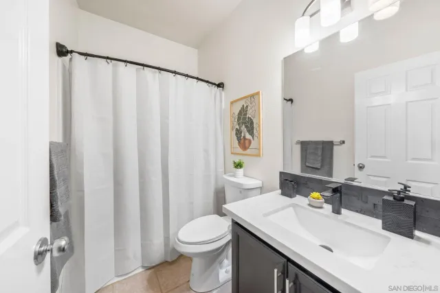 a bathroom with a sink a toilet and shower curtain