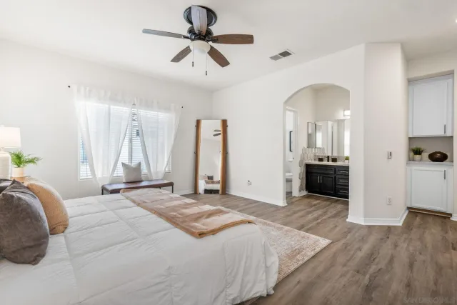 a spacious bedroom with a large bed and ceiling fan