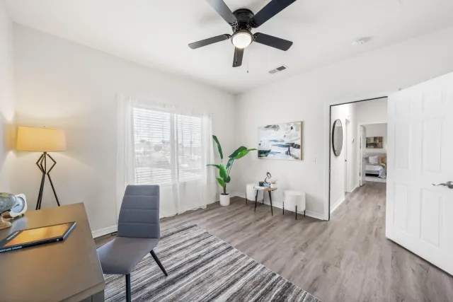 a living room with furniture and a wooden floor