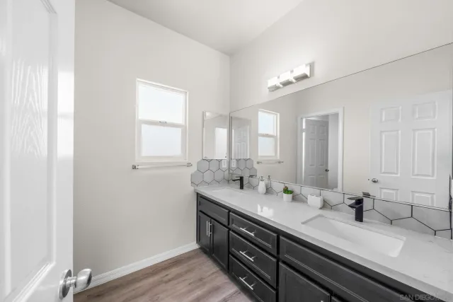 a bathroom with double sink and a mirror