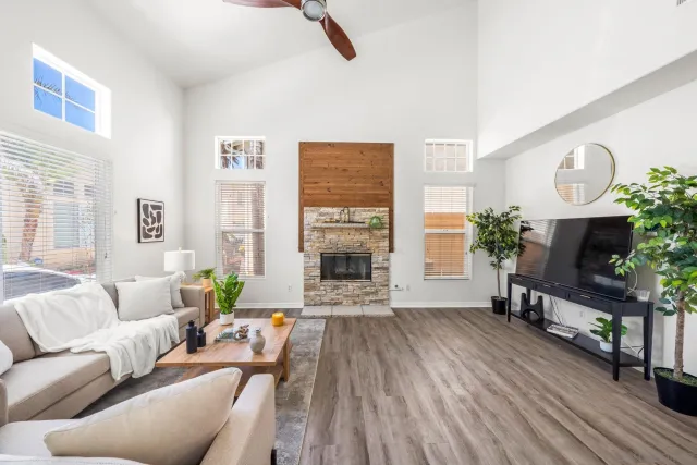 a living room with furniture a fireplace and a large window