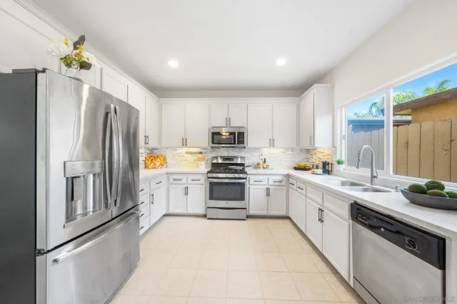 a kitchen with granite countertop a refrigerator stove and sink