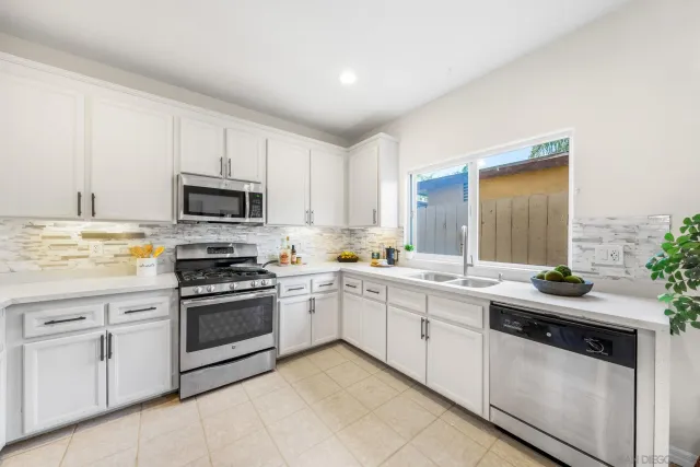 a kitchen with white cabinets appliances and a sink