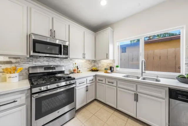 a kitchen with cabinets stainless steel appliances and a sink