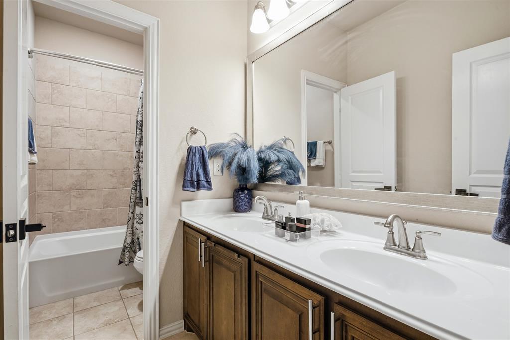 1802 Roundtree Road Forney, TX 75126 - Photo 33 of 39 a bathroom with a double vanity sink a mirror and a bathtub