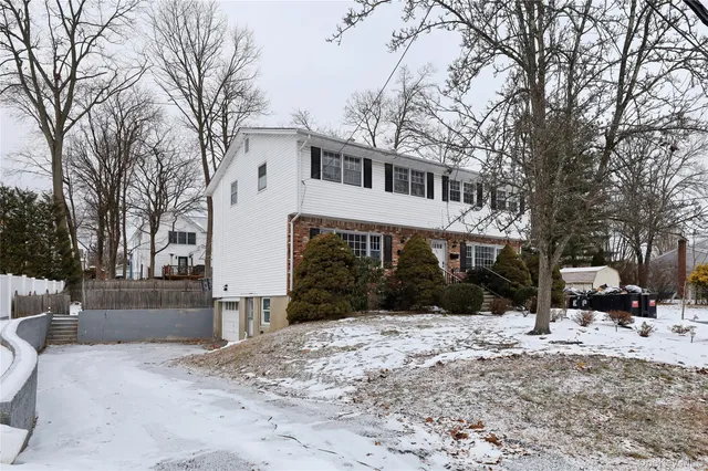 a front view of a house with a yard covered in snow