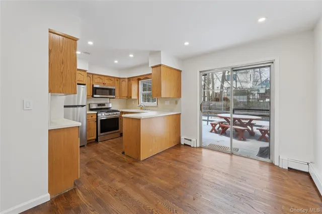 a kitchen with stainless steel appliances granite countertop a stove top oven a sink and a refrigerator