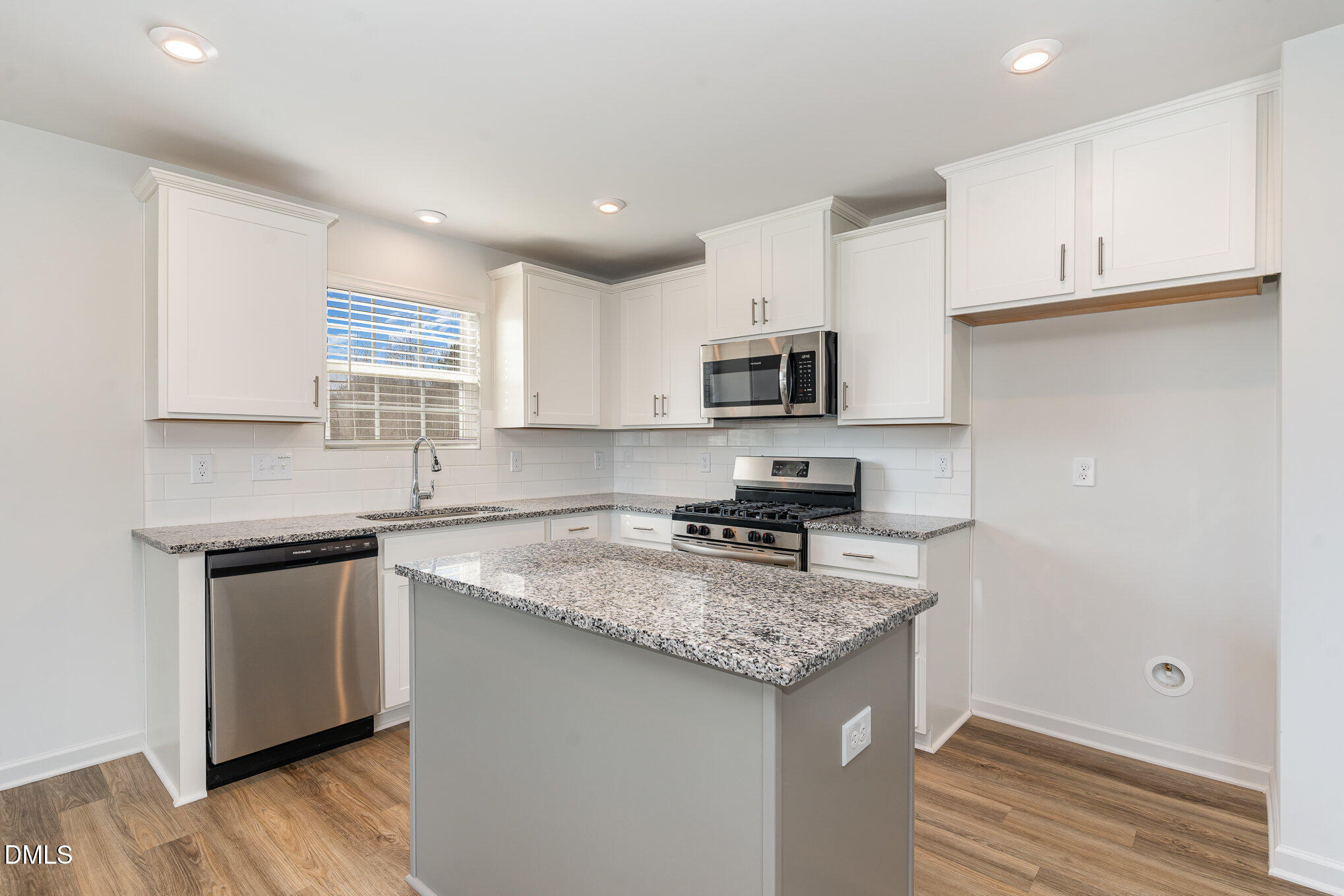 385 Dasu Drive, Unit 1 Clayton, NC 27520 - Photo 5 of 17 a kitchen with granite countertop a sink stove and cabinets
