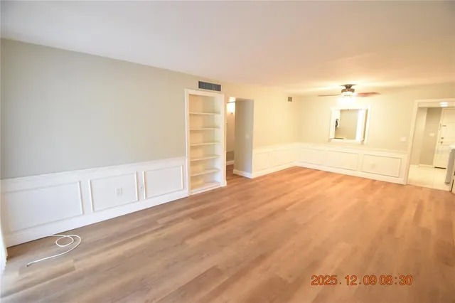 a view of empty room with wooden floor and cabinet