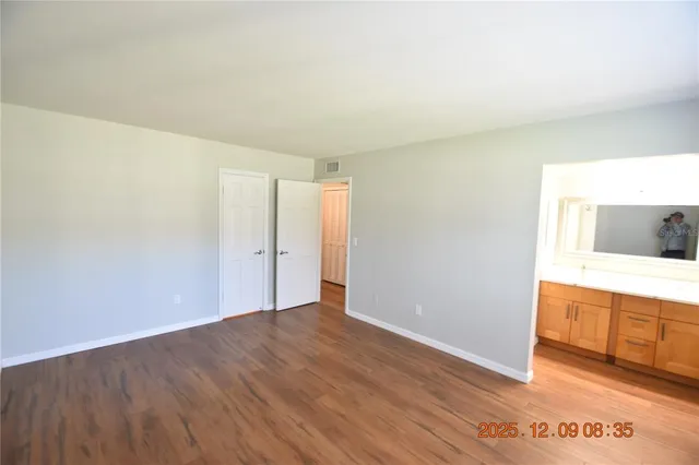 a view of an empty room with wooden floor