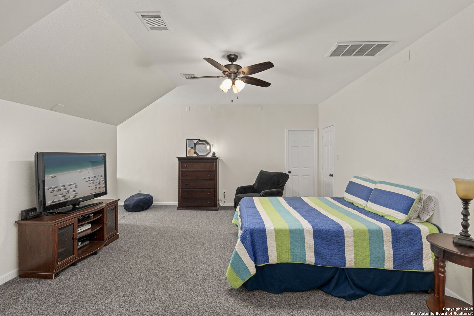 16106 Ponderosa Pth Helotes, TX 78023 - Photo 31 of 40 a bedroom with bed and a chandelier