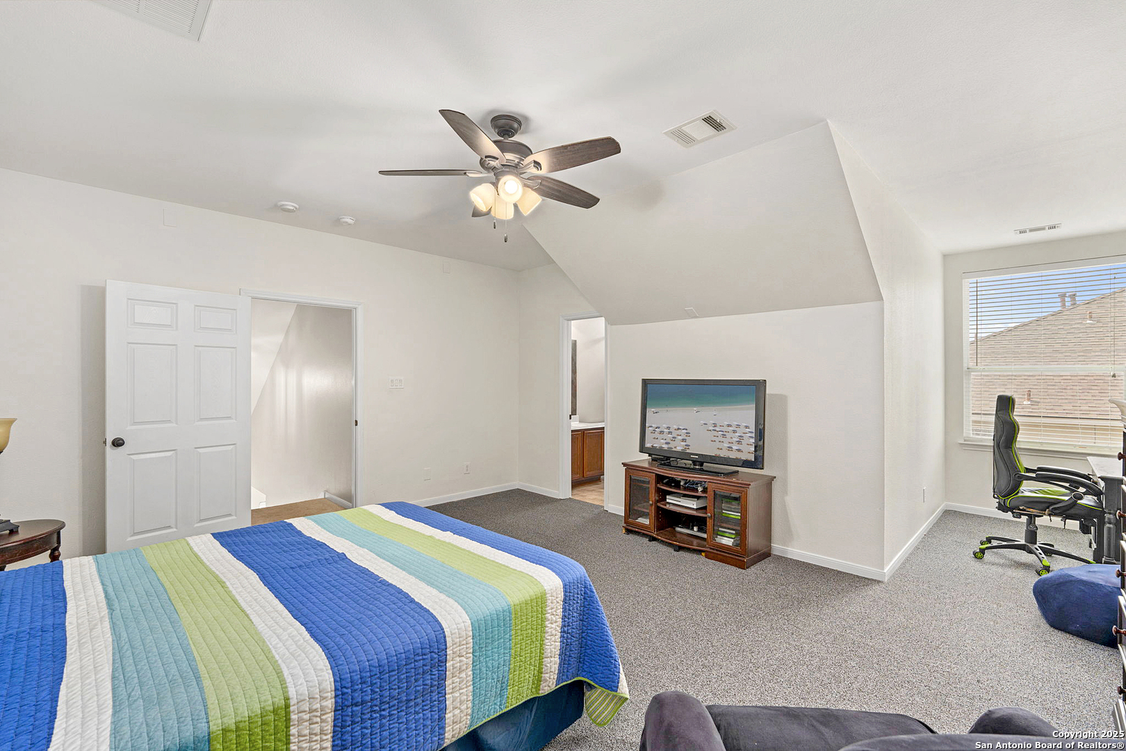 16106 Ponderosa Pth Helotes, TX 78023 - Photo 32 of 40 a bedroom with a bed and a chandelier