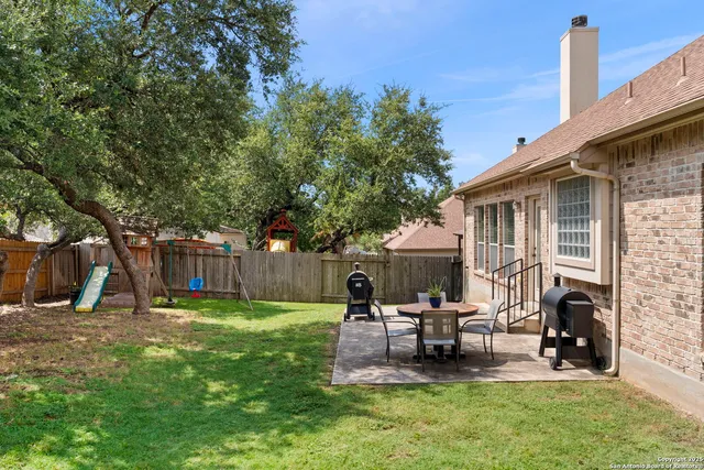 a view of a house with backyard and sitting area