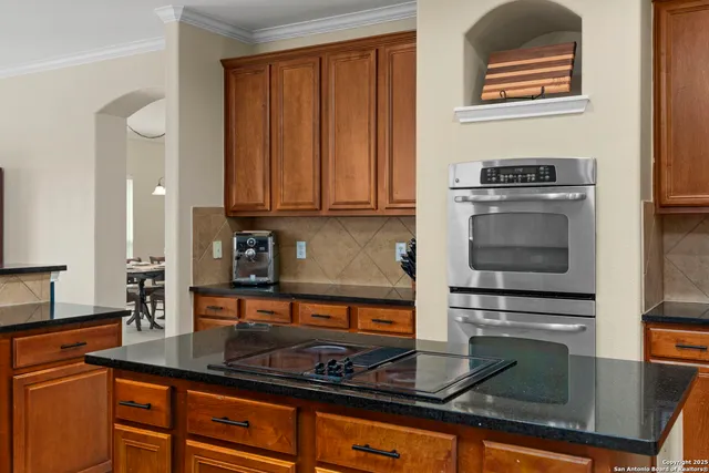a kitchen with kitchen island granite countertop a stove and a sink