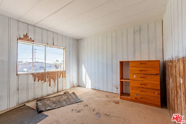 an empty room with a window and doors