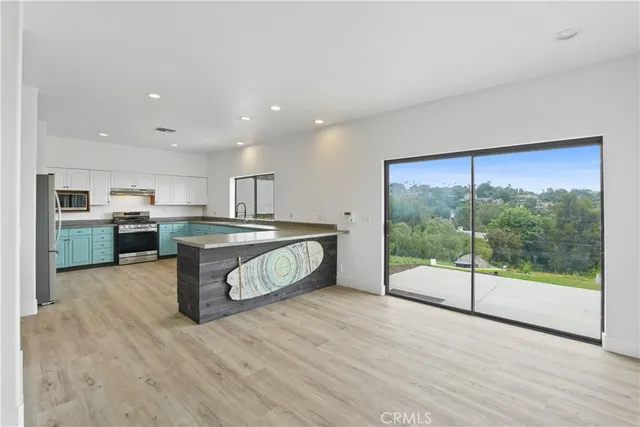 a view of kitchen with stainless steel appliances granite countertop a large stove top oven and a counter space