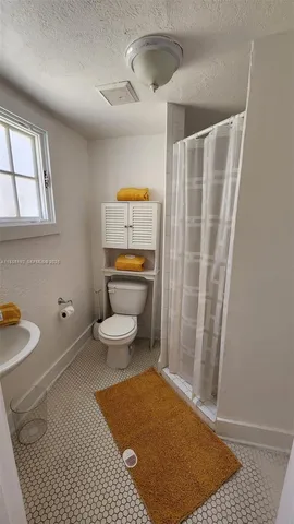 a bathroom with a toilet and a shower