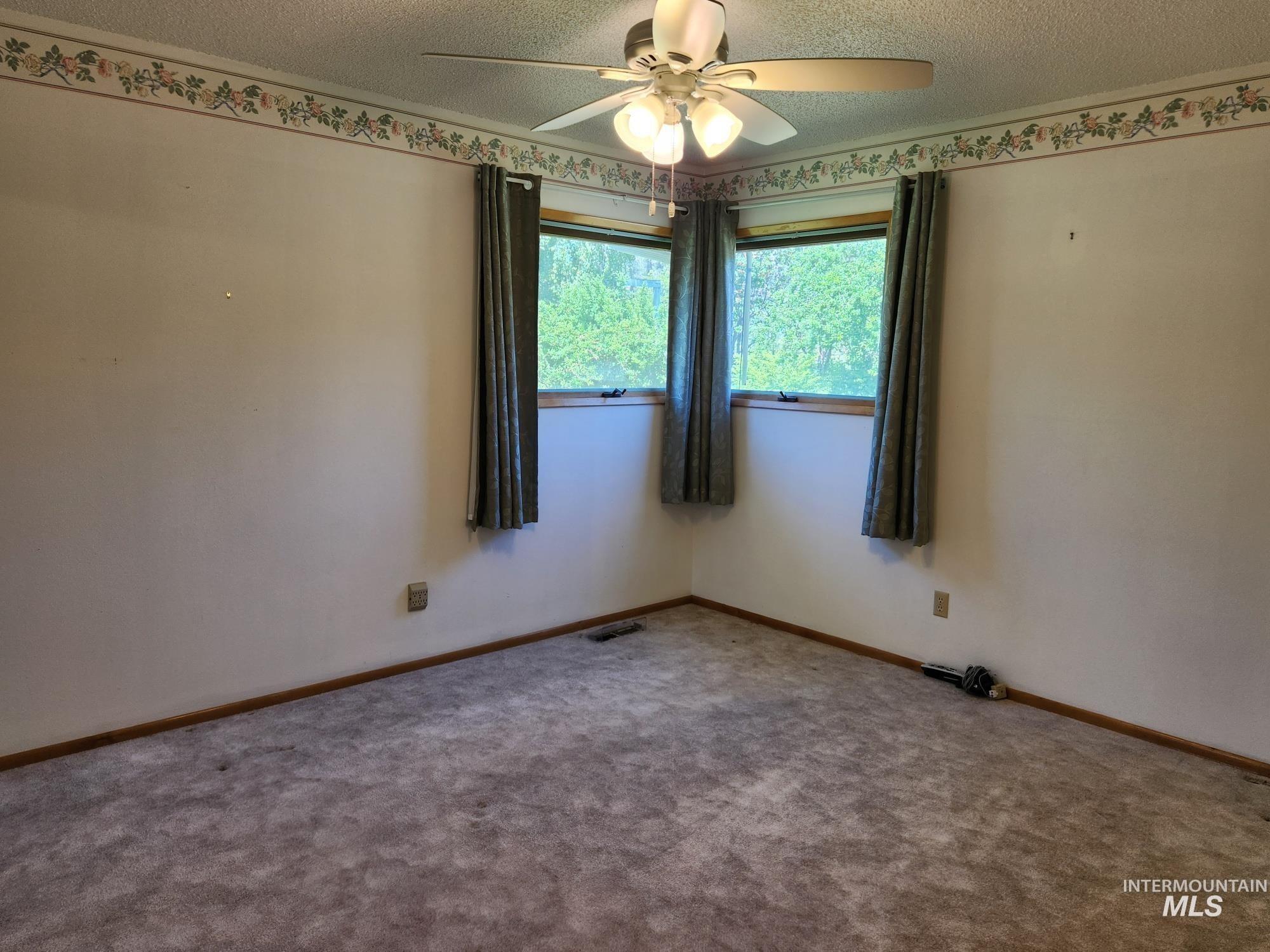 367 Woodland Road Kamiah, ID 83536 - Photo 13 of 45 Carpeted empty room with a ceiling fan and a textured ceiling