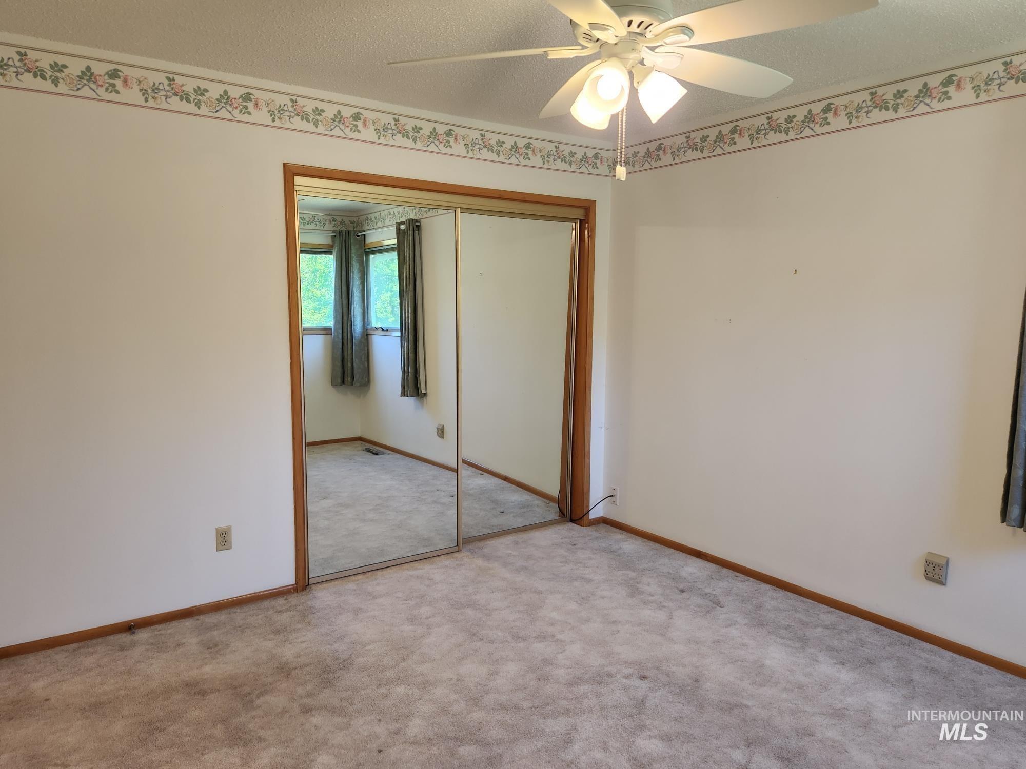 367 Woodland Road Kamiah, ID 83536 - Photo 14 of 45 Unfurnished bedroom with a textured ceiling, a closet, carpet flooring, and a ceiling fan