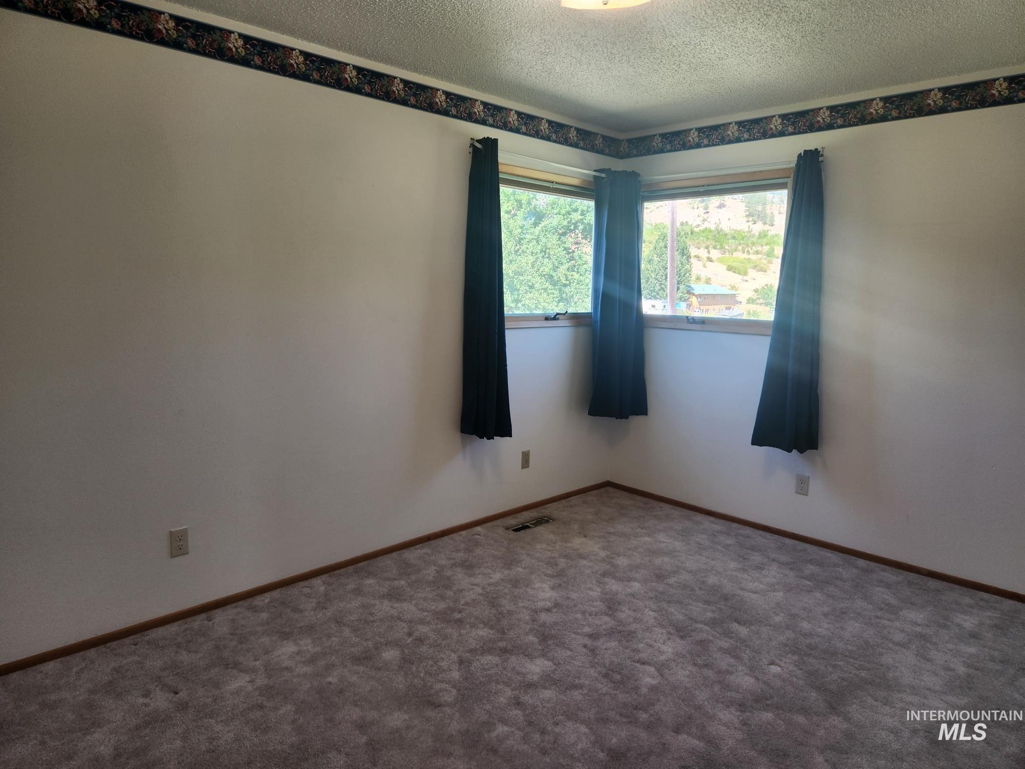 367 Woodland Road Kamiah, ID 83536 - Photo 16 of 45 Carpeted spare room featuring a textured ceiling and baseboards